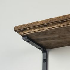 a close up of a wooden shelf with metal brackets on the top and bottom part