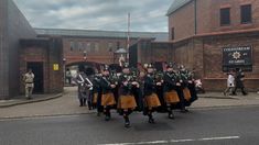 some men in kilts are marching down the street