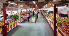 an indoor market filled with lots of fresh fruits and vegetables