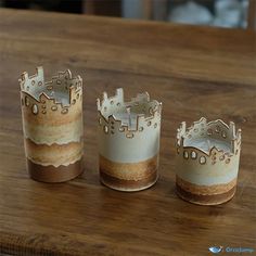 three candles are sitting on a table with one candle holder in the shape of a castle