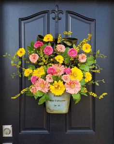 a bucket filled with flowers sitting on top of a door