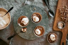 four desserts are arranged on a table with spoons