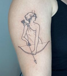 a woman with a bow and arrow tattoo on her arm is holding a toothbrush