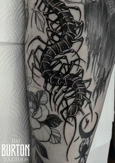 a black and white tattoo with flowers on it