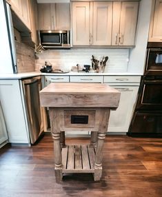 a small wooden table sitting in the middle of a kitchen