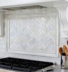 a stove top oven sitting inside of a kitchen next to a counter with utensils