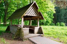 a small wooden structure in the middle of a forest with steps leading up to it