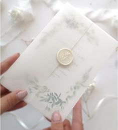 a close up of a person holding a piece of paper with a button on it