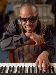 a man with sunglasses on playing the piano