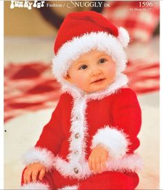 a baby in a santa suit sitting on the floor