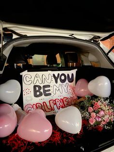 the back of a car with balloons, flowers and a sign that says can you be my girlfriend?