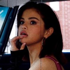 a woman sitting in the back seat of a car talking on a cell phone