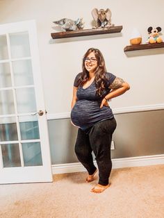 a pregnant woman standing in front of a door