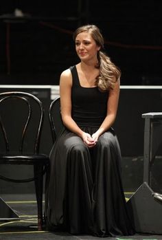 a woman sitting on top of a black chair