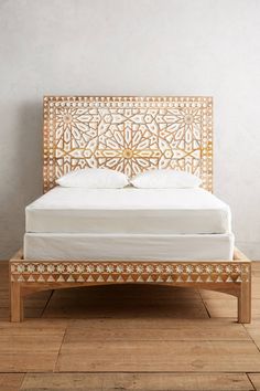 a bed with an intricate wooden headboard and foot board