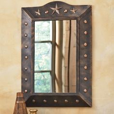 a mirror sitting on top of a wooden table next to a lamp and window sill