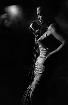 a black and white photo of a woman holding a microphone