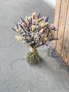 a bouquet of flowers sitting on the ground next to a wooden door