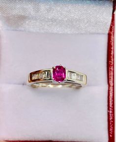 a pink sapphire and diamond ring in a box