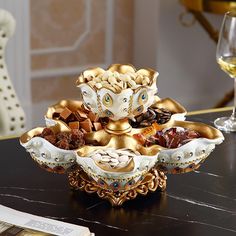 an ornately decorated dish on a table next to a glass of wine