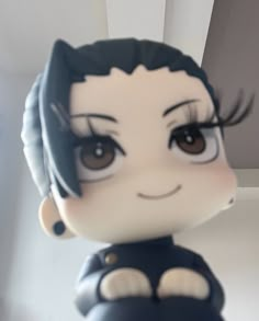 a close up of a small doll with big eyes