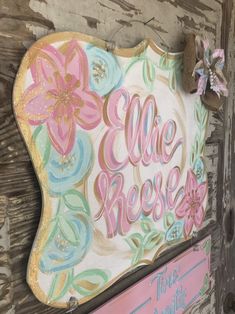 a wooden sign that says,'the rose'and has flowers painted on it