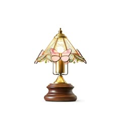 a lamp that is sitting on top of a wooden base and has pink butterflies on it