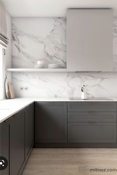 a kitchen with marble counter tops and gray cabinets