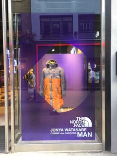 the north face storefront window with mannequins dressed in orange and blue