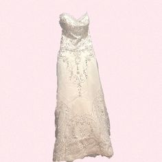 a white wedding dress hanging on a pink wall