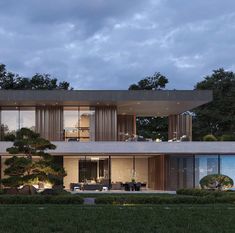 a large modern house with trees in the front yard and an outdoor dining area on the second floor