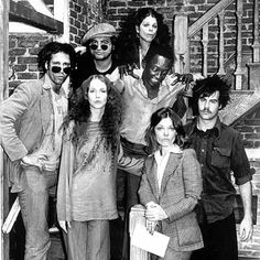 a group of people that are standing on the stairs together in front of a brick building