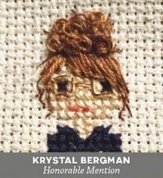 a close up of a needled doll on a piece of cloth with the words, krysstal bergman memorable mention