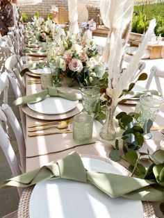 the table is set with white and green place settings