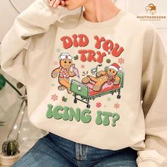 💖 Add a playful touch to your holiday wardrobe with this funny Gingerbread Nurse Christmas Sweatshirt! Featuring the humorous phrase "Did You Try Icing It?"--perfect for school nurses, trauma nurses, and healthcare workers with a love for holiday humor. This retro-style sweatshirt is ideal for spreading cheer during the festive season. It makes a thoughtful and amusing gift for any nurse who deserves a smile this Christmas! ☘️ PRODUCT DETAILS:  🔥Classic T-Shirt:  👉 5.3 oz., 100% preshrunk cot Nurse Ugly Christmas Sweater, Nurse Christmas Sweater, Christmas Shirts For Nurses, Funny Christmas Nurse Shirts, Christmas Nurse Shirts Vinyl, Funny Christmas Outfits, Jumper Ideas, Funny Holiday Shirts, Sassy Tee