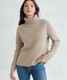 a woman wearing a turtle neck sweater and jeans