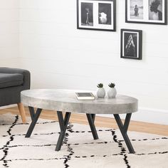 a living room with white walls, black and white rugs and pictures on the wall