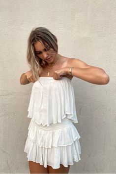 STYLE INFORMATION: The Monaco White Strapless Romper is a vacay dream! White woven rayon fabric falls from a strapless neckline, with no-slip strips, to a flowy, ruffle overlay bodice with an on-trend smocked overlap back detail. Attached shorts complete the look. DETAILS & CARE: Lined. 100% Rayon. Hand wash cold. Imported. SHIPPING: Orders are processed within 1-2 business days. Packages are shipped out Monday-Friday, holidays are excluded. Bandeau Tube Top With Smocked Back For Beach, Chic Bandeau Tube Top For Brunch, Flirty Strapless Tube Top For Day Out, Strapless Ruffled Tops For Day Out, Strapless Tube Top With Smocked Back For Beach, Summer Bandeau Tube Top For Brunch, Summer Tube Top With Smocked Back For Vacation, Chic Smocked Back Tube Top For Beach, Strapless Ruffled Tube Top For Day Out