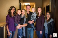 a group of people standing next to each other in a hallway with their arms around one another