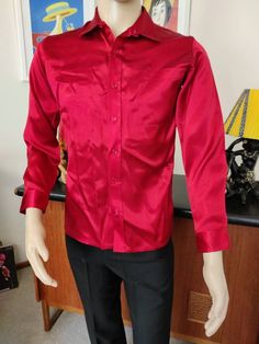 This red satin shirt was difficult to capture the closest match as to colour. It is not a raspberry as the first photo. Maybe fire engine red and so shiny too. It is marked a small 36/37cm. The condition is good Measurements are Shoulder to shoulder 39cm Chest 98cm Sleeves shoulder to cuff 59cm Length shoulder to hem 68cm Fitted Red Shirt For Party, Formal Red Long Sleeve Shirt, Red Collared Shirt For Party, Red Collared Party Shirt, Red Long Sleeve Formal Shirt, Fitted Long Sleeve Satin Shirt, Classic Red Tops For Party, Classic Red Top For Party, Classic Red Party Tops