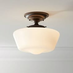 a light fixture hanging from the ceiling in a room with white walls and wood trim