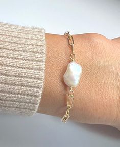 This stylish Gold Paper Clip bracelet is made of 14k gold filled with solid rectangular open links all around. It's accented with a natural white keshi pearl with a unique organic shape and amazing luster. Bracelet is fully adjustable in the length of your choice, and fastens with a lobster claw clasp. Wear it by itself or layer it with other Camla designs, day or night, it always looks so chic and elegant. Metal: 14k gold filled Chain dimensions: 9 mm x 3 mm links Gemstone: Keshi pearl Elegant Gift Jewelry: Oyster Bracelet With Rectangular Links, Modern Baroque Pearl Jewelry As Gift, Modern Pearl Bracelet With Charm As A Gift, Modern Pearl Bracelet With Pearl Charm As Gift, Modern Pearl Bracelet With Pearl Charm For Gift, Keshi Pearl Bracelet, Paper Clip Bracelet, Gold Paper, Keshi Pearls