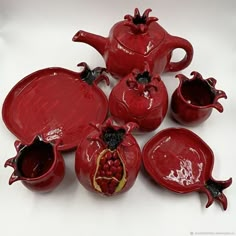 a group of red ceramic items on a white surface