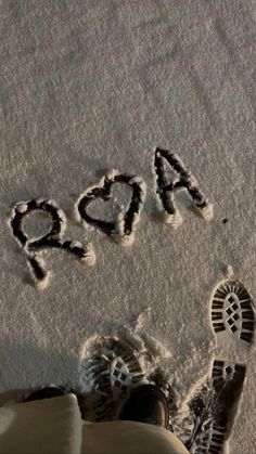 someone is standing in the snow with their feet up and there are letters that spell out