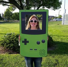 a woman holding up a video game controller costume for the cameraman in front of her