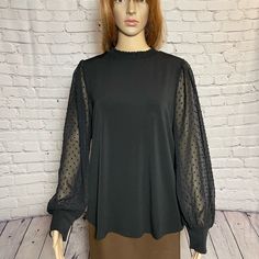 Chic And Sophisticated, Our Stretch Knit Crepe Top Is Elevated With Clip Dot Long Sleeves. Obsessed With The Flattering Smocked Mock Neckline. Team This Pullover Top With Your Favorited Pair Of Jeans For Your Casual Days And Dressy Pants For A Night Out On The Town. Smocked Mock Neck Stretch 95% Polyester, 5% Elastane Size L Length: 26'' ,Pit To Pit: 22'' New With Tag B-19(13) Fitted Swiss Dot Tops For Fall, Elegant Polka Dot Top For Fall, Fitted Polka Dot Blouse For Fall, Fitted Black Blouse With Elastic Sleeves, Fall Party Blouse With Swiss Dot Details, Black Swiss Dot Blouse For Spring, Chic Black Swiss Dot Top, Black Blouse With Elastic Sleeves For Work, Sleeveless Wrap Top