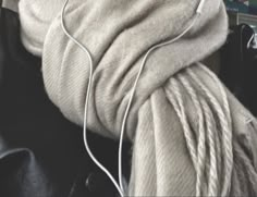 a pair of white headphones sitting on top of a black chair next to a blanket