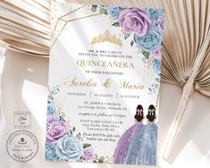 the wedding card is decorated with blue and purple flowers, gold trimmings, and a tiara