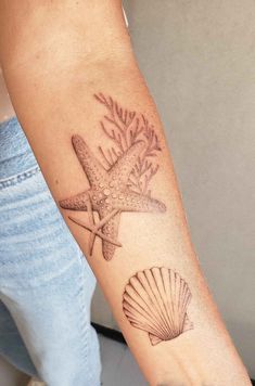 a person with a starfish and seashell tattoo on their arm is holding a fan