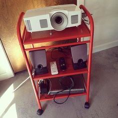 a projector sitting on top of a red shelf